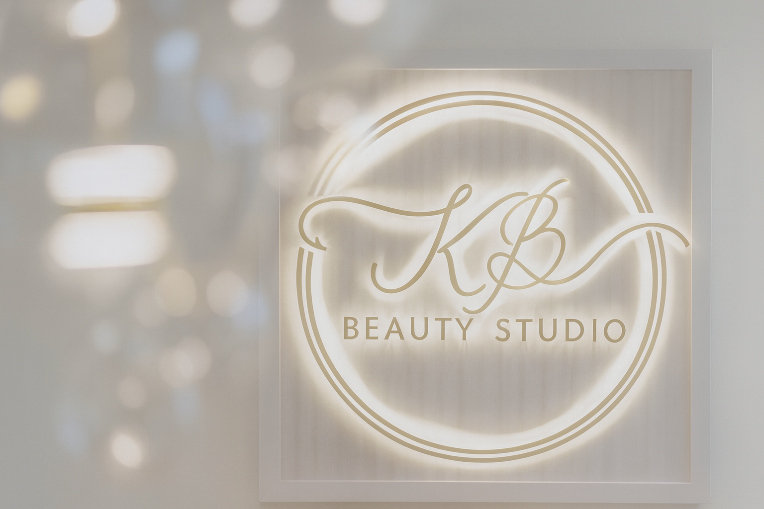 Neon sign with 'KB Beauty Studio' logo on a blurred background
